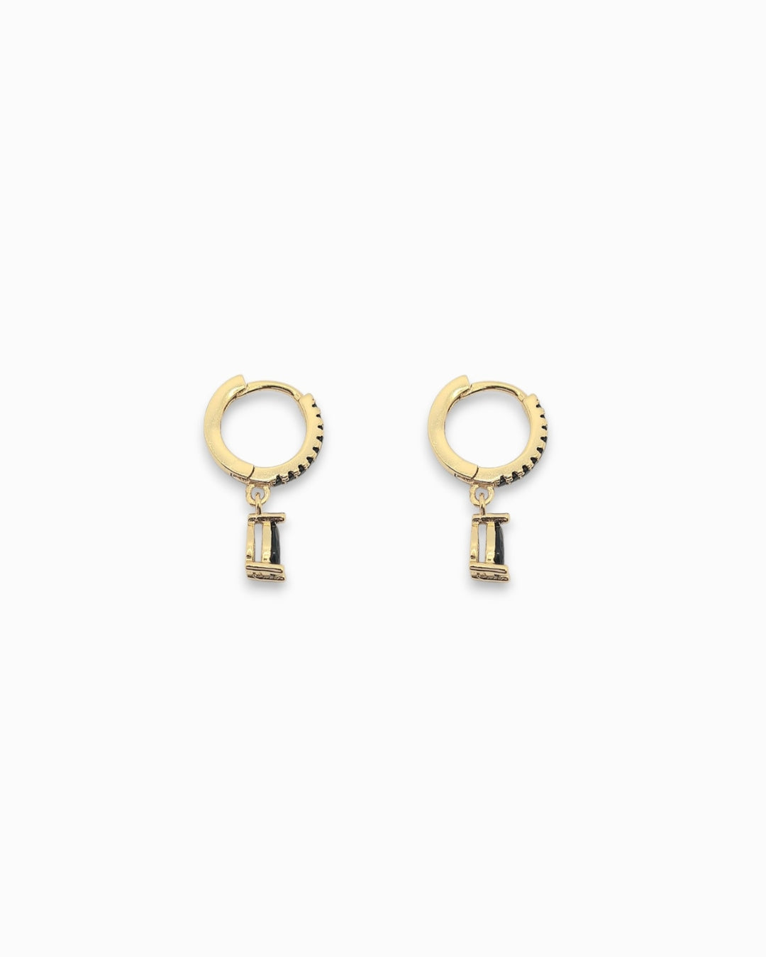 18k Gold pendant hoop earrings with small rectangular teardrop shaped black stones in the pendant flat lay on white background
