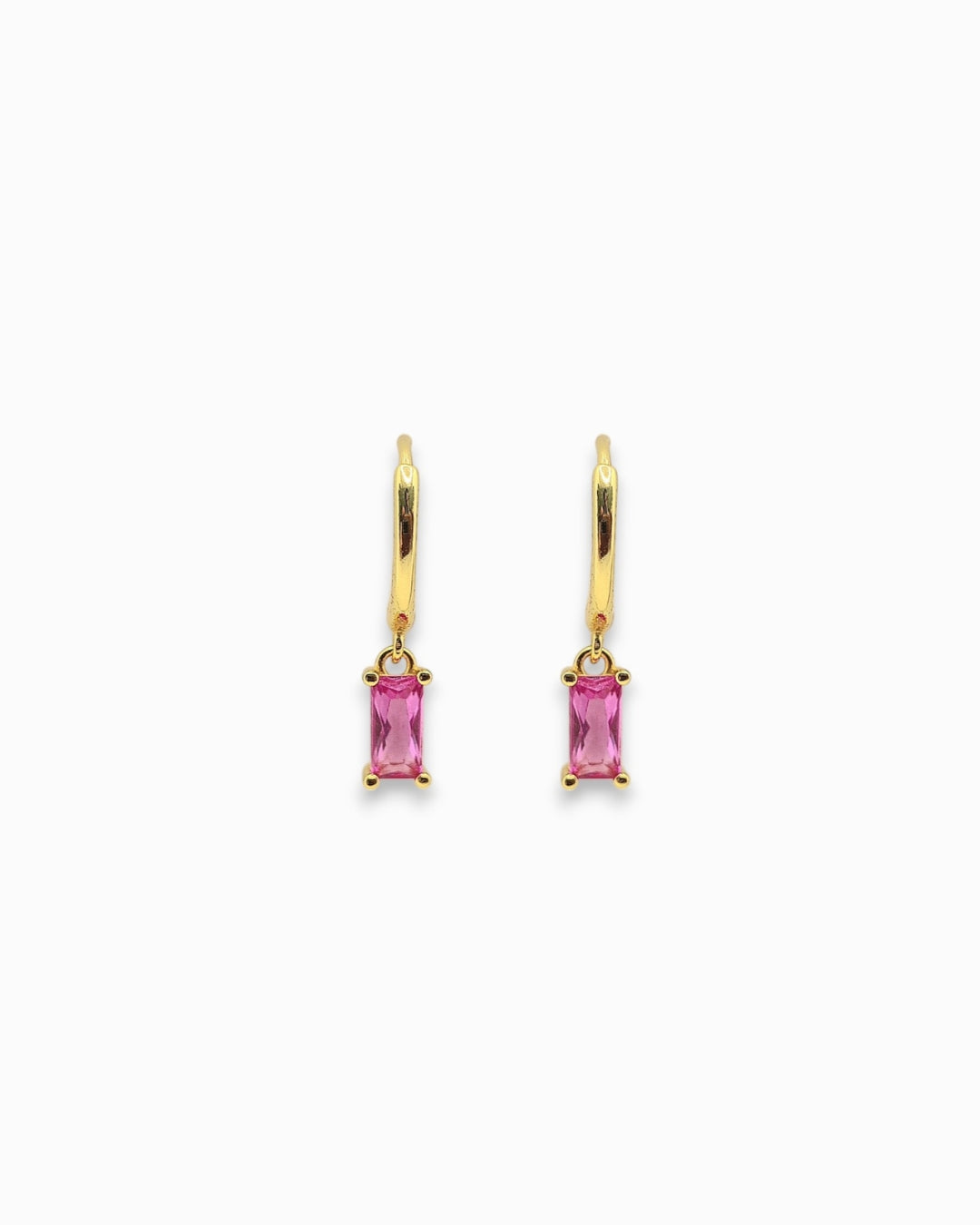 Gold pendant hoop earrings with pink gemstones on a white background