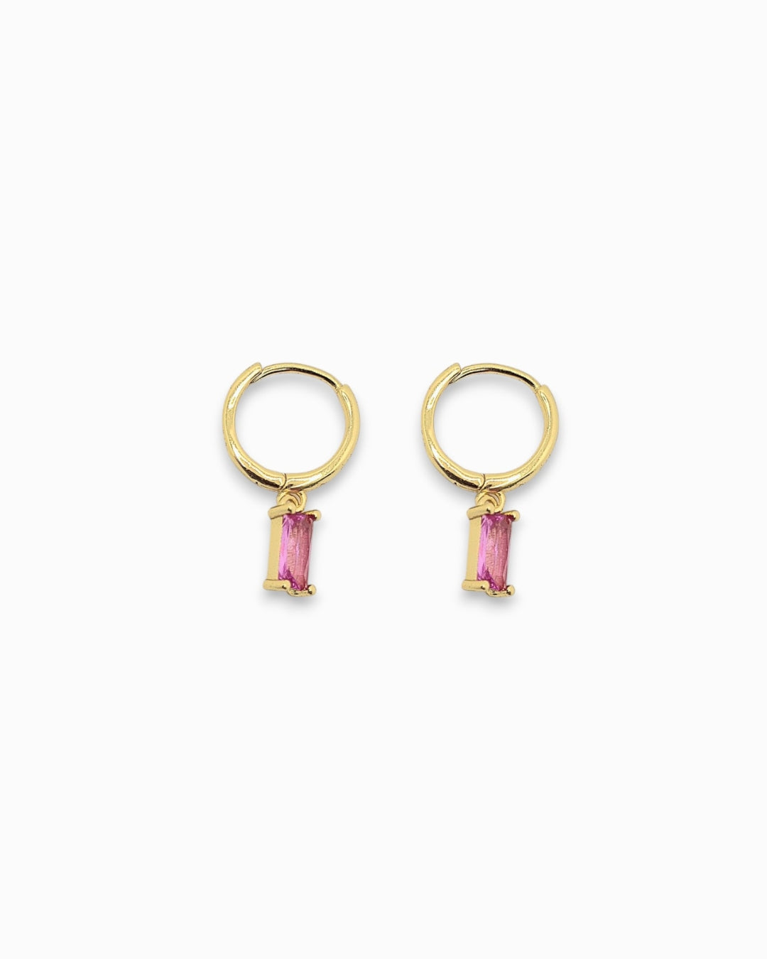 Gold pendant hoop earrings with pink gemstones flat lay on a white background