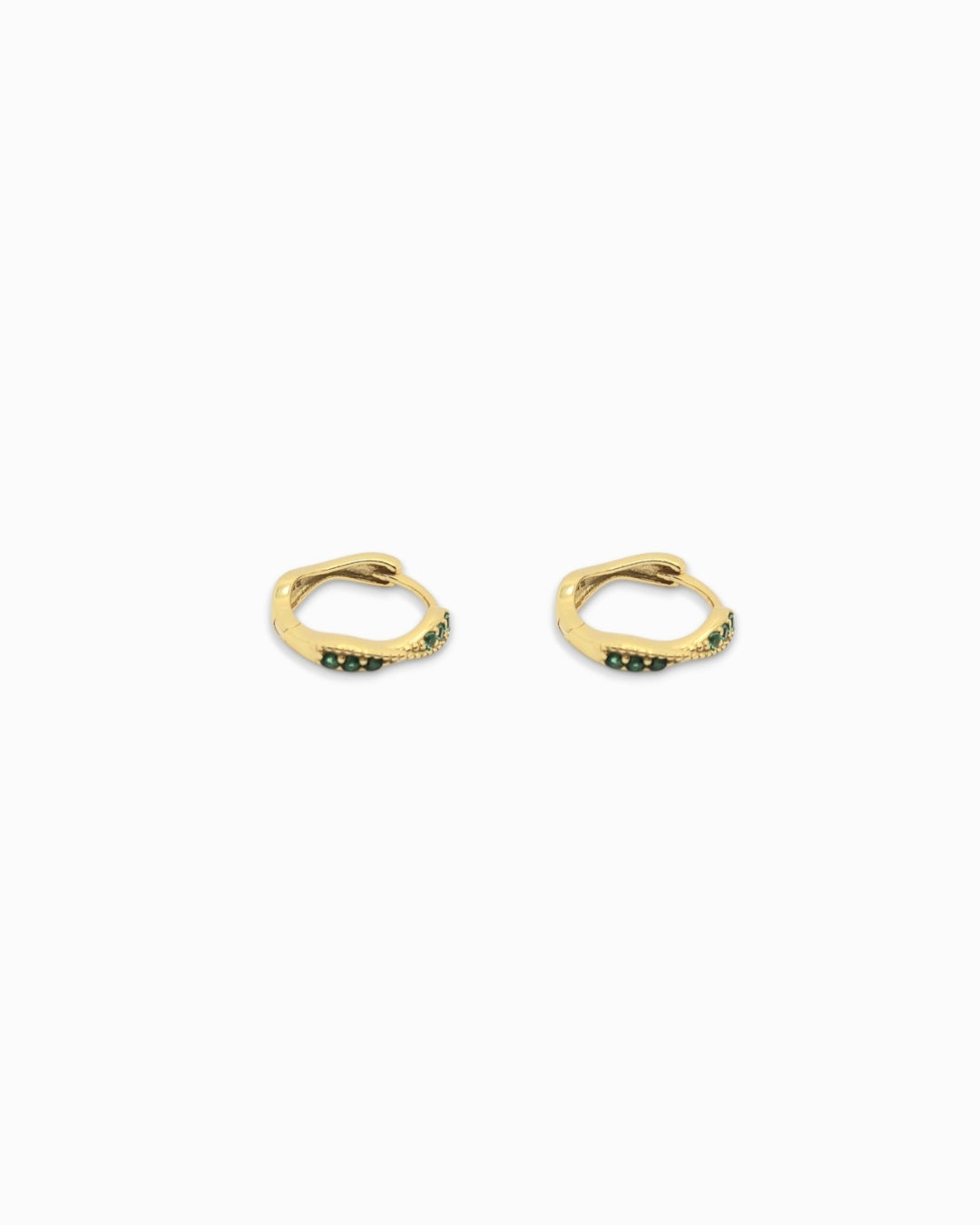 Gold huggie earrings with embedded stones on a white background
