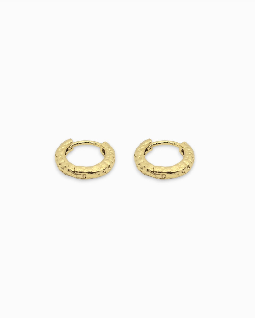 Gold hoop huggie earrings with a textured finish on a white background