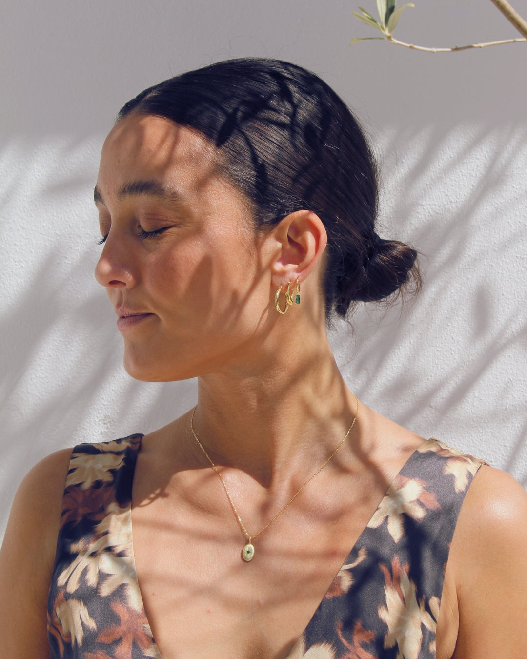 Woman wearing a floral dress and 18 carat gold jewellery that is plated to 925 sterling silver