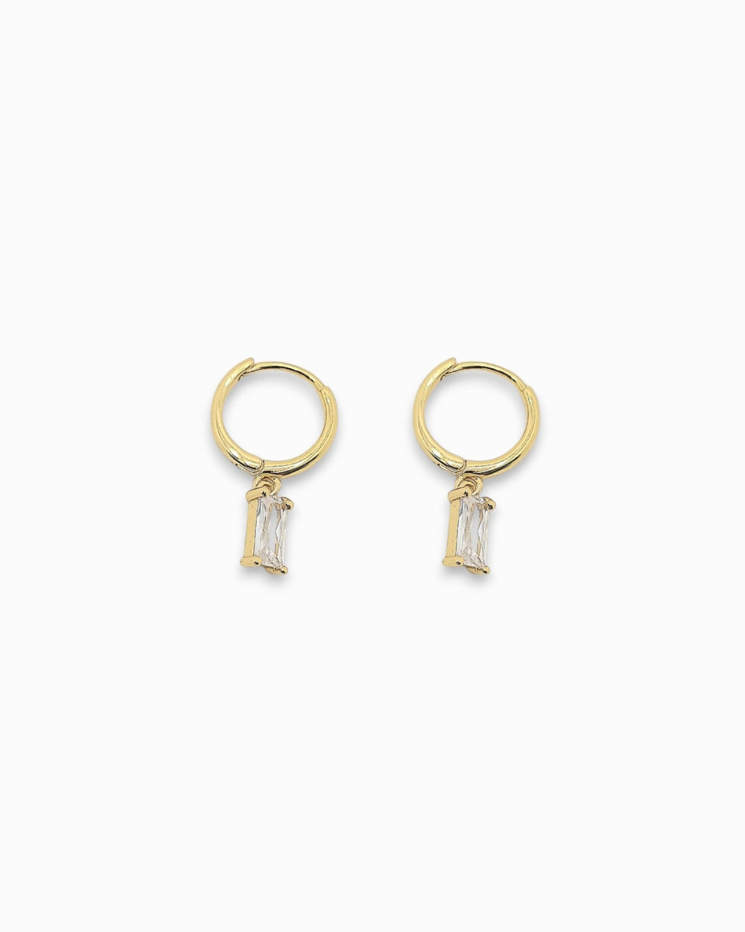 Gold pendant hoop earrings with clear gemstones on a white background