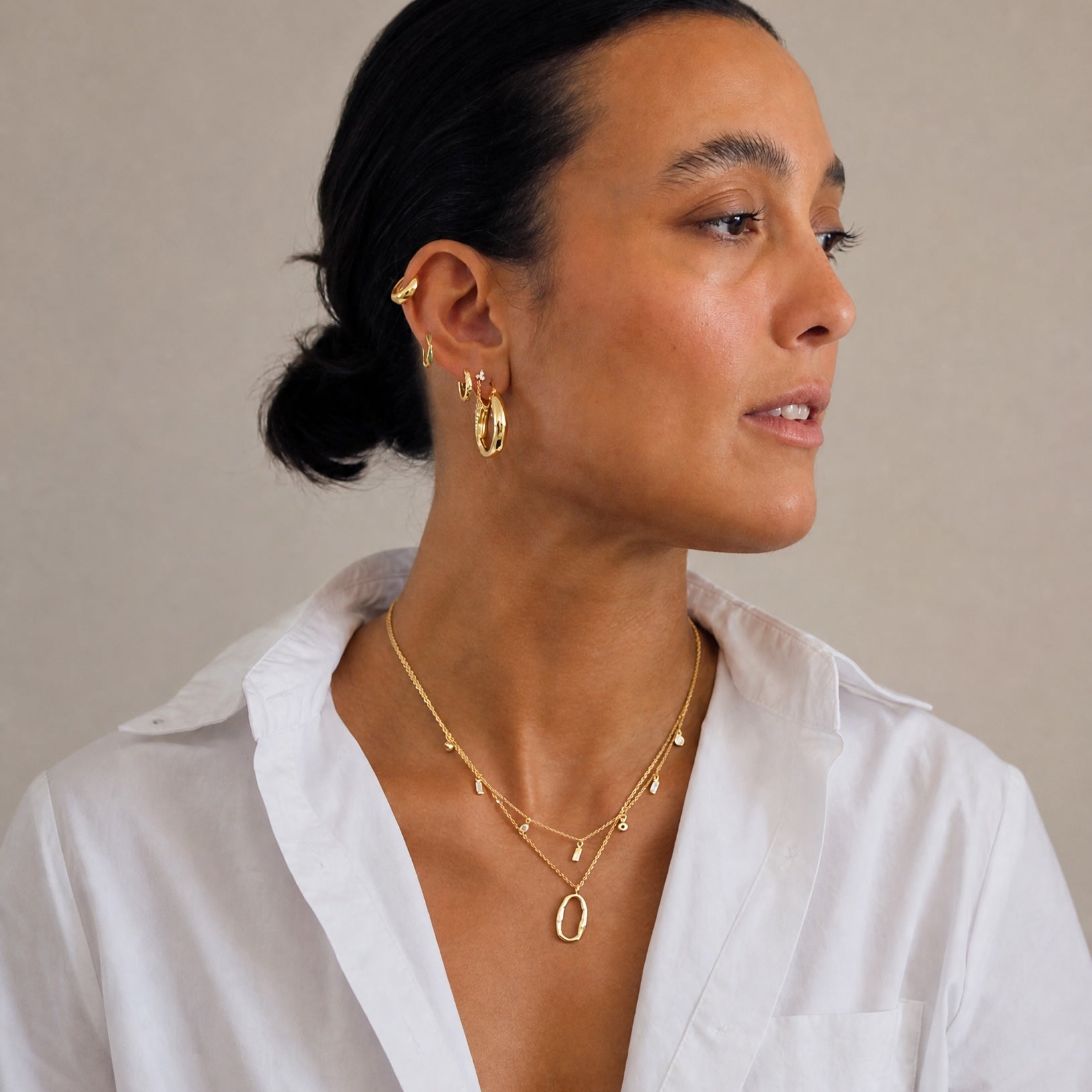 Model wearing the Hunter Rose Maisie 18k gold plated necklace with clear stones, styled with matching demi-fine jewellery.