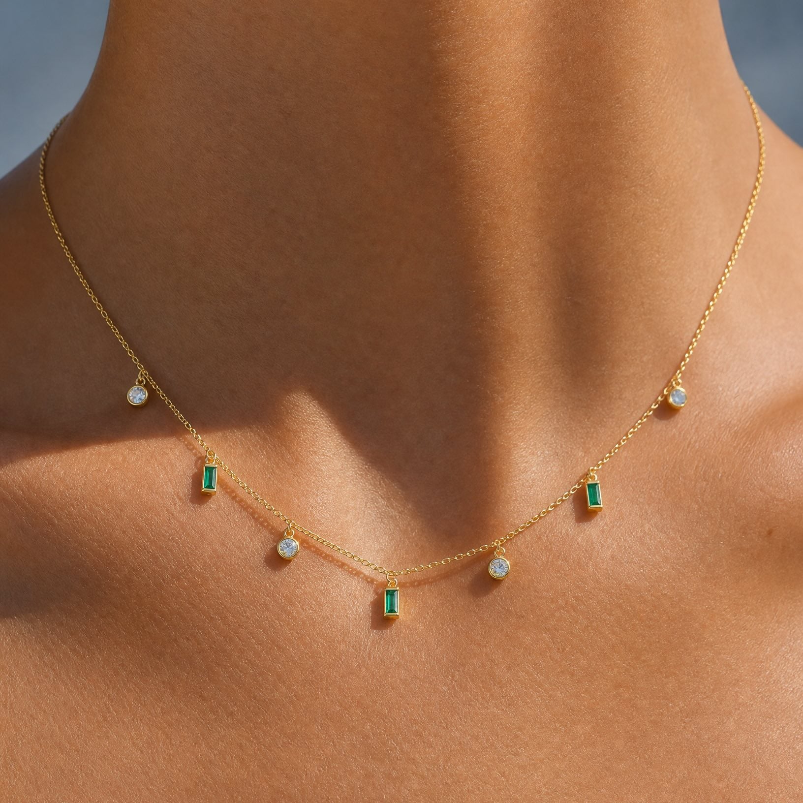 Close-up on the collarbone showcasing the demi-fine Maisie 18k gold plated necklace with green stones by Hunter Rose.