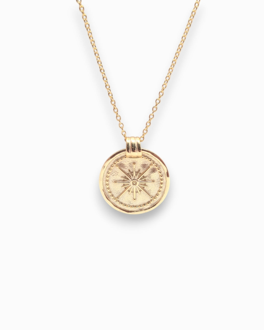 Gold necklace with a round pendant on a white background