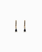 Pair of gold pendant hoop earrings with black teardrop stones on a white background