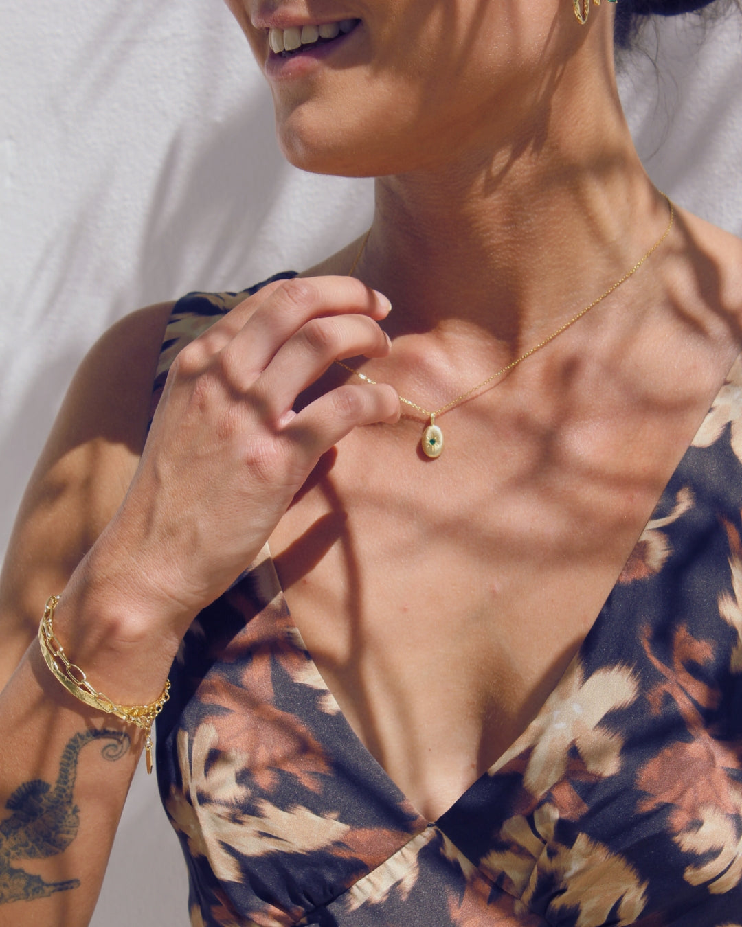 Woman wearing a 18k gold plated to 925 sterling silver necklace and  hammered textured bracelet.