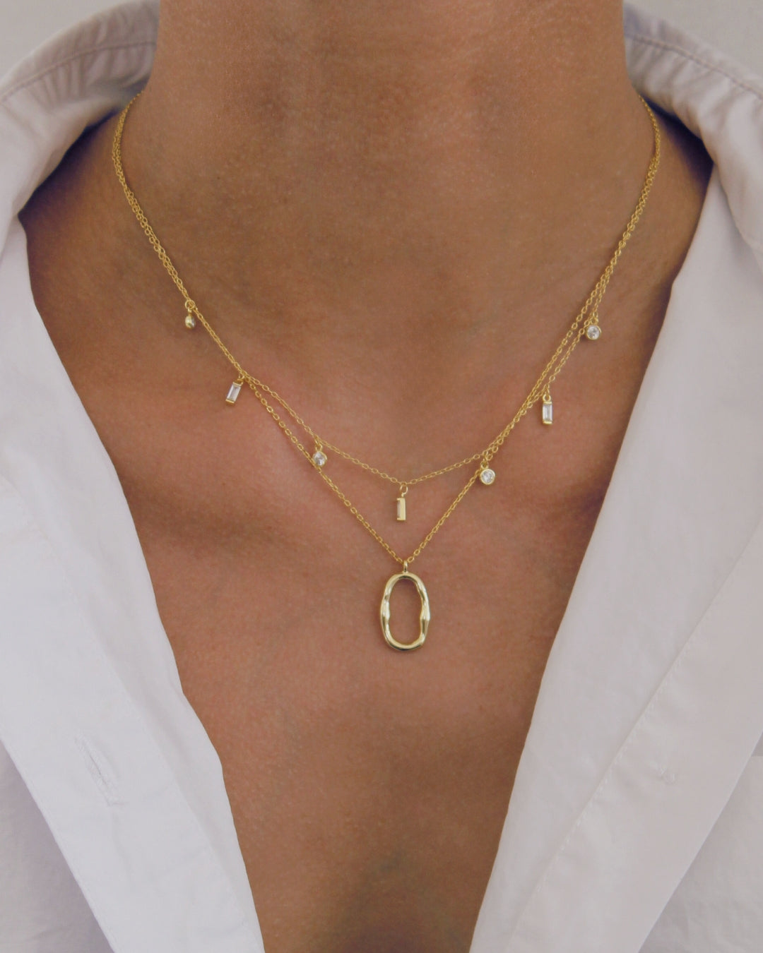 18k Gold necklace with a pendant on a person wearing a white shirt.