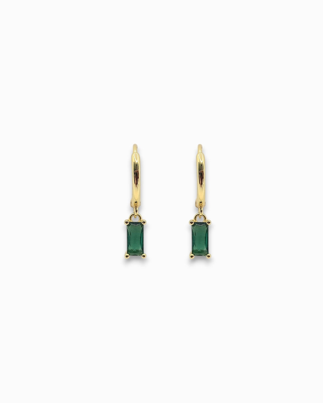 Gold pendant hoops earrings with green gemstones on a white background
