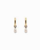 Gold hoop earrings with pearl drops on a white background