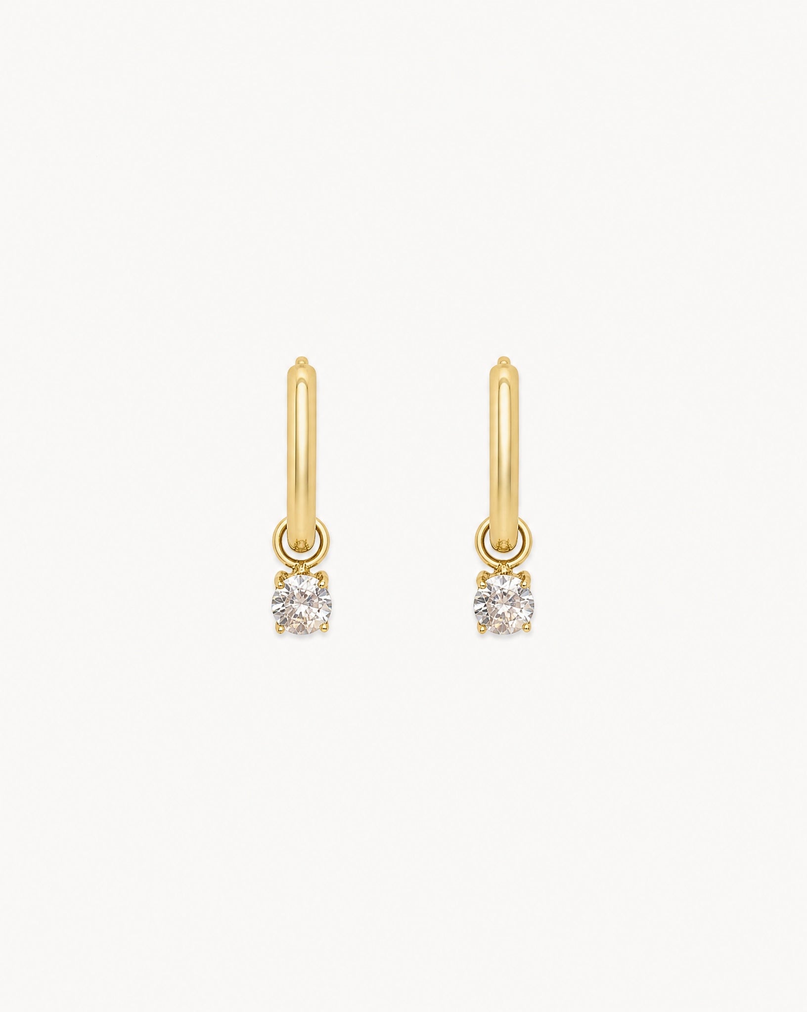 Studio view of the Hunter Rose Aria 18k gold waterproof pendant hoop earrings featuring a clear stone.