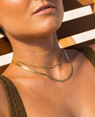 Close-up on a model wearing the layered tarnish-free 18k gold snake chain bundle by Hunter Rose.