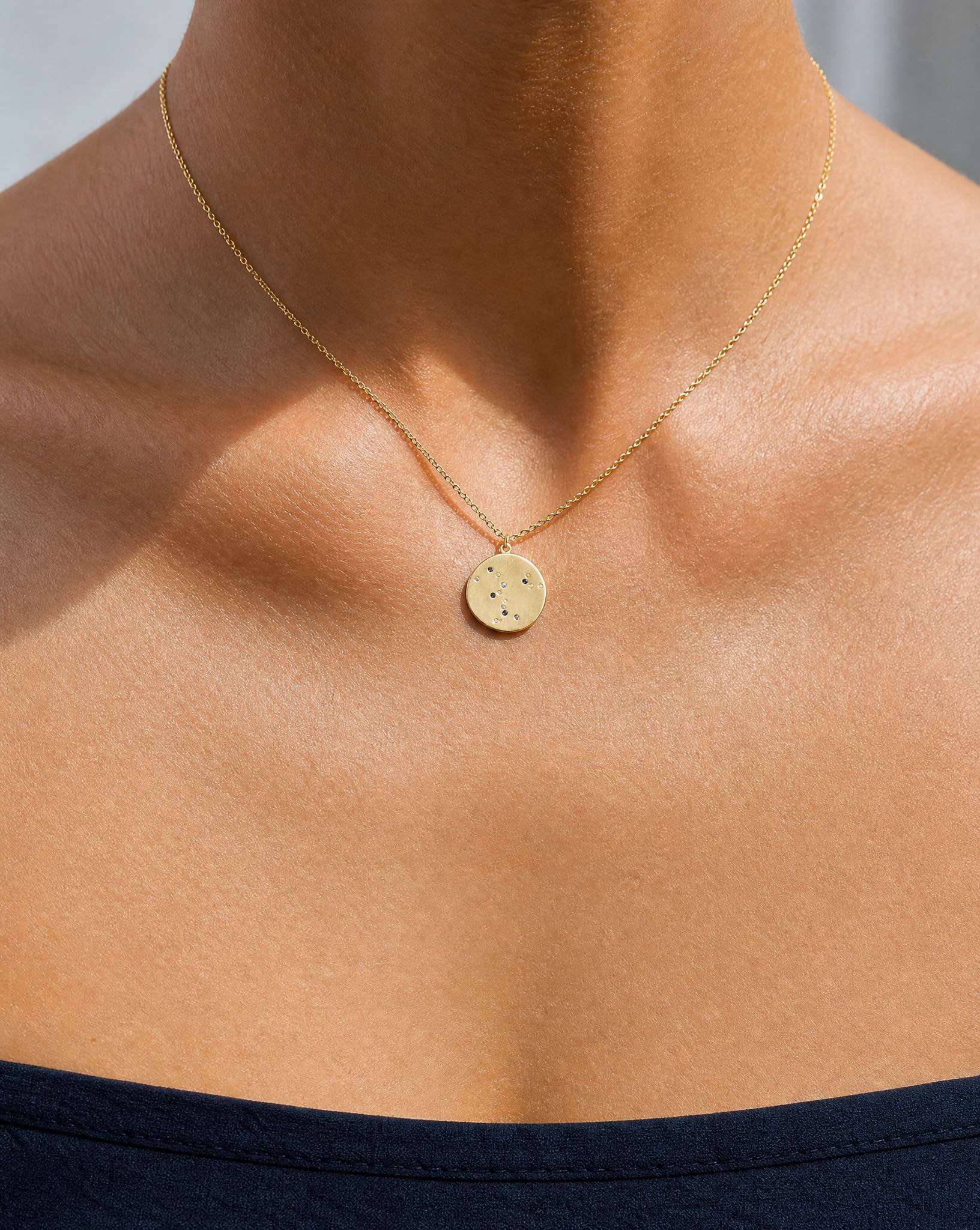 Close-up on the collarbone showcasing the Luna 18k gold constellation coin pendant necklace by Hunter Rose.