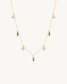 Studio view of the Hunter Rose Maisie 18k gold plated necklace featuring round clear stones and green baguette stones.