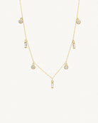 Studio view of the Maisie 18k gold plated necklace featuring round and baguette clear stones by Hunter Rose.