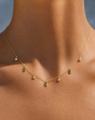 Close-up on the collarbone showcasing the demi-fine Maisie 18k gold plated necklace with green stones by Hunter Rose.